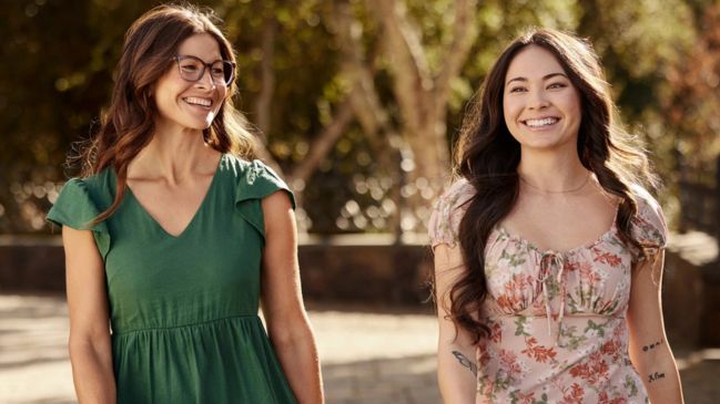 Two women walking outside and smiling